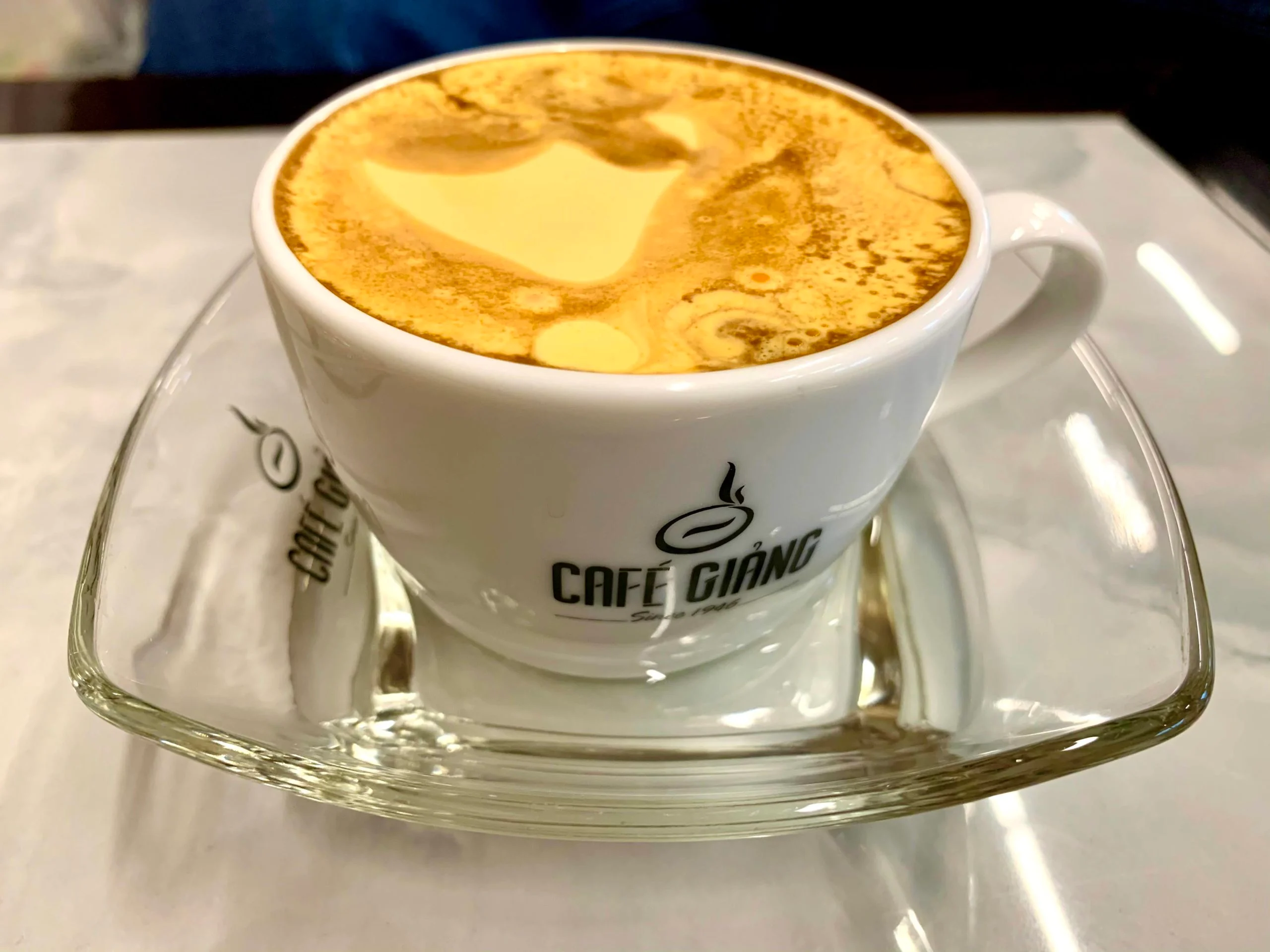 Ly café trứng với lớp kem trứng bồng bềnh, vàng óng.