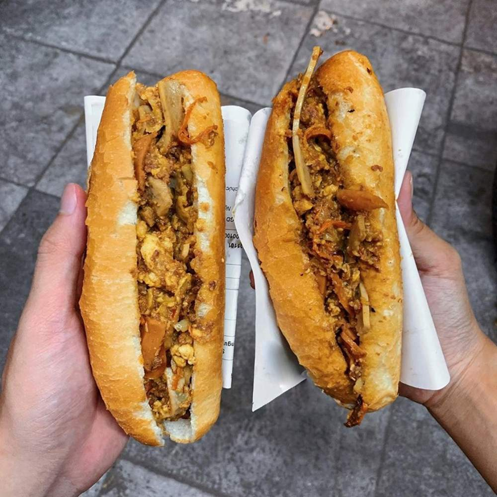 Ổ bánh mì nhân pate, trứng, thịt nướng đầy đặn.